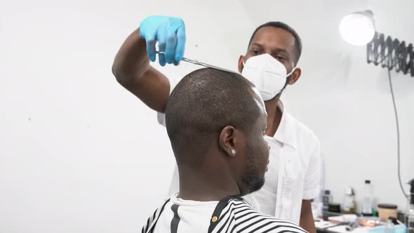 Barber cutting hair of a customer in barber shop