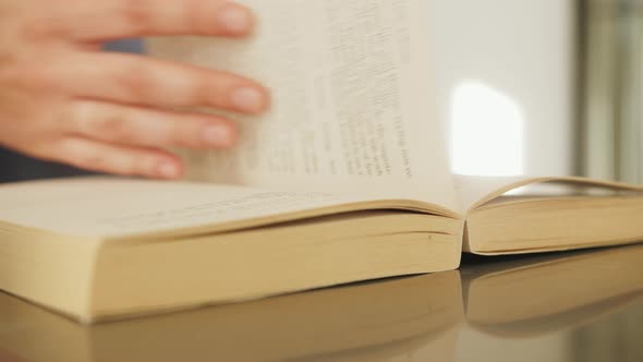 Close Up Hand Turning Pages of Book