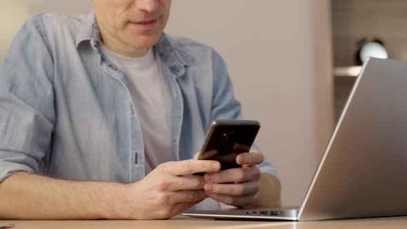 Cropped view of the caucasian man using mobile phone for call while sitting at the desk