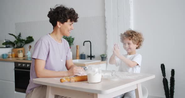 Naughty Boy Clapping Dirty Hands Covered with Flour Cooking with Mother at Home