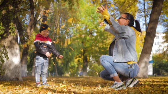 Mom Playing with Son in Autumn Park. Happy Moments Together. Family in the Autumn Park.