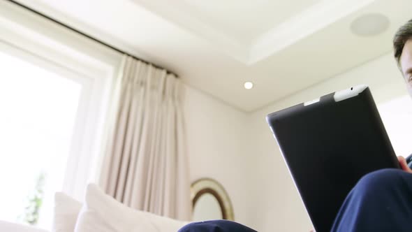 Mature man using digital tablet at home