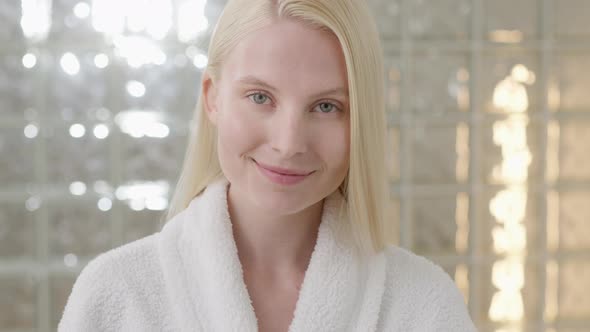 Young Caucasian Woman With Long Blond Hair Wearing a Bath Towel Looking at Camera in a Bright