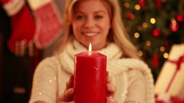 Pretty blonde holding candle at christmas