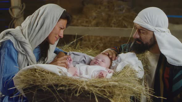 Mary and Joseph Speaking with Baby Jesus in Manger