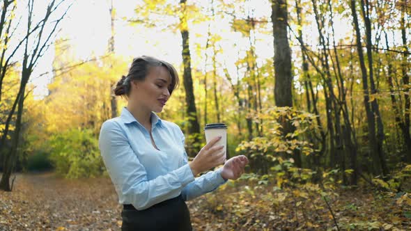 Woman drinking hot tea. Woman warm up with hot tea in autumn park