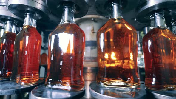 Glass Bottles with Alcohol Are Getting Moved By the Transporter