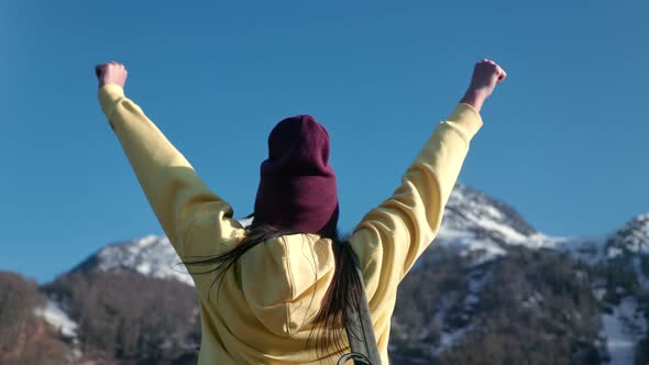 Winner Backpacker Female Celebrating Victory Freedom Independence at Mountain Snowy Peak Back View