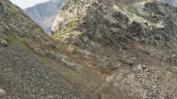 People climb to the top of the mountain against the background of clouds.