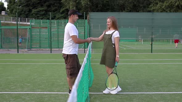 The guy greets the girl before playing tennis