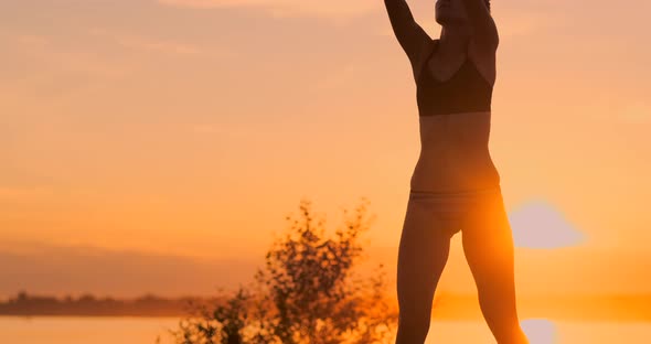 Middle Distance Volleyball Girl in Bikini Waiting for the Ball on the Court at Sunset Gives Forearm