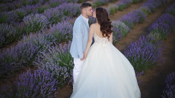 a Young Happy Couple in Love is Walking in a Field of Lavender Flowers