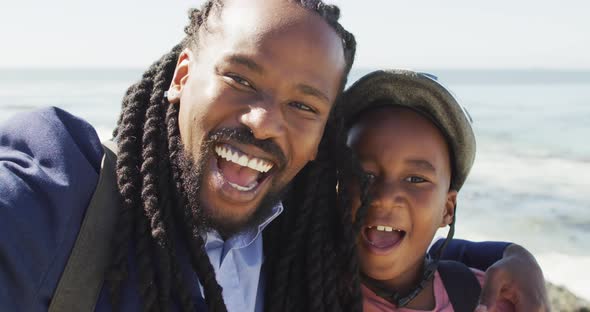 Video of happy african american father and son in helmet taking selfie outdoors