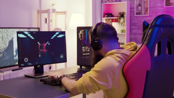 Man in a Room with Colorful Neon Lights Sitting on Gaming Chair