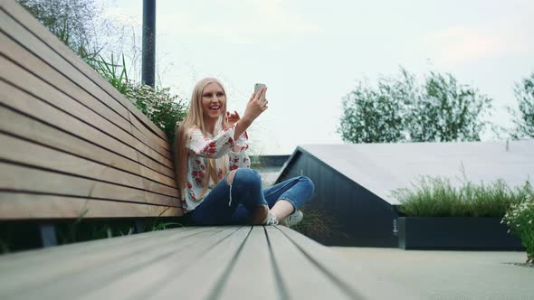 Young Lady Making Video Call on Green Roof.