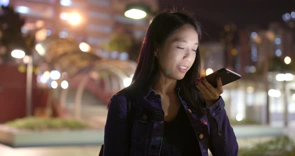 Woman use of mobile phone in city at night