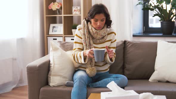 Sick Young Woman in Scarf Drinking Hot Tea at Home 13