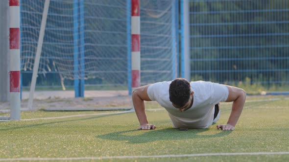 Young Sportsman Footballer Indian Guy in Summer Sportswear Doing Biceps Push Up Exercises Exercising