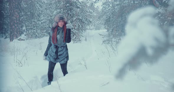 Beautiful Girl Walking Along the Path Between the Snowdrifts in the Forest