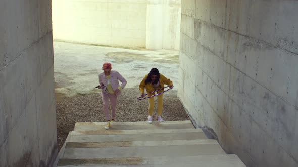 Bizarre fashionable women running on steps