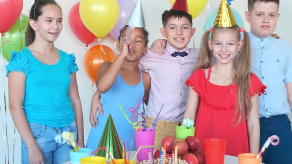 AfricanAmerican Girl Blows Horn at Birthday with Friends