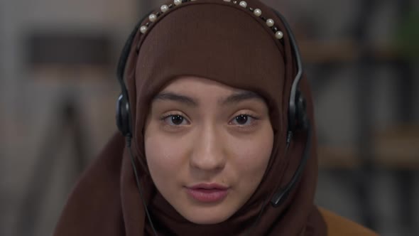 Headshot Portrait of Young Confident Middle Eastern Woman in Headphones and Hijab Talking Looking at / Videohive