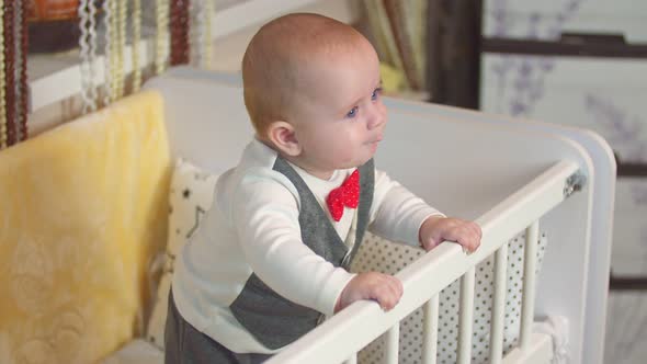 Little Boy Stands in the Crib