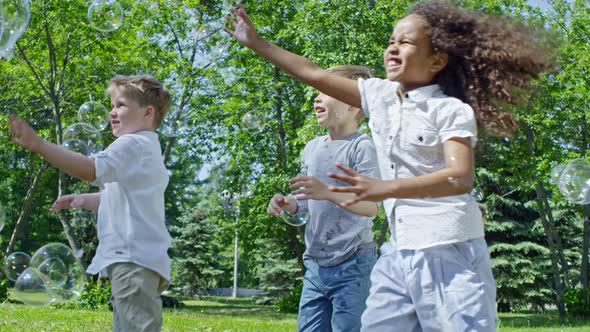 Cheerful Kids Chasing Soap Bubbles alt