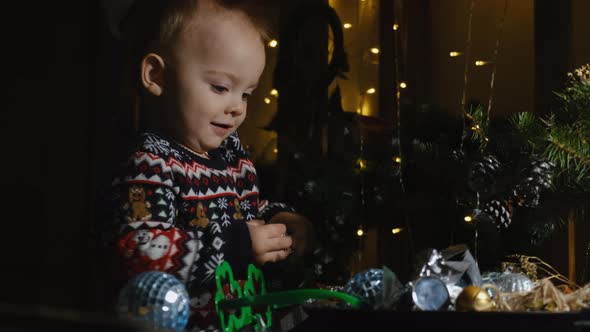 Toddler Boy Playing with Christmas Baubles at Home