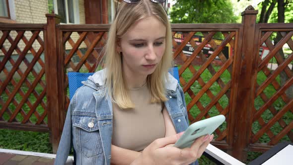 Relaxed young girl using smartphone surfing social media, close up