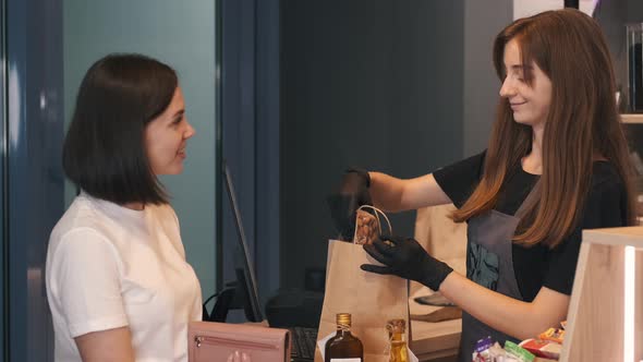 Female Customer and Assistant Packing the Ingrediets Into a Bag