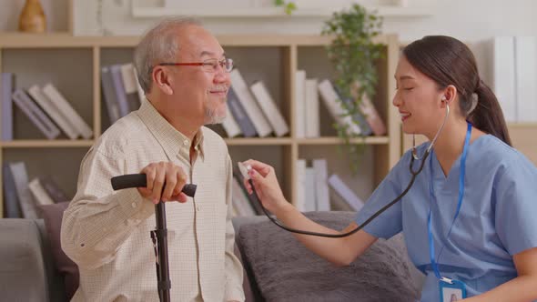 Female doctor use stethoscope to examine Asian elderly patient heartbeat. Caring female doctor use t