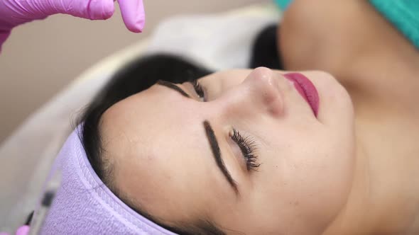 The young beautiful woman in a spa receiving facial treatment injections.