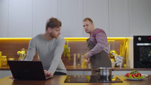 Homosexual Partners Preparing Food in Kitchen