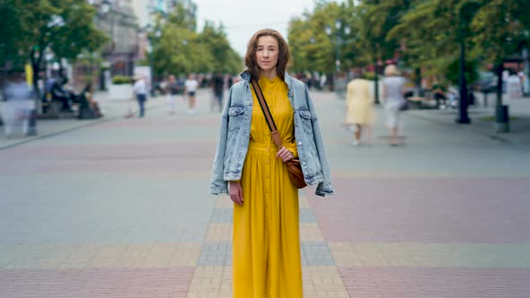 Zoomin Time Lapse of Attractive Young Lady Standing in Busy Street Among People Passing By