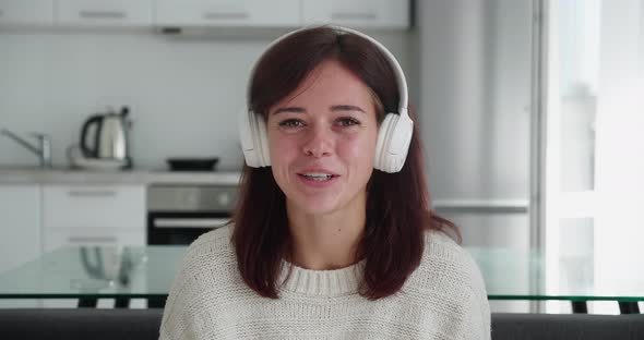 Screen Webcam View of Joyful Young Woman in Earphones Talk Before Camera with Smile Meet Friend