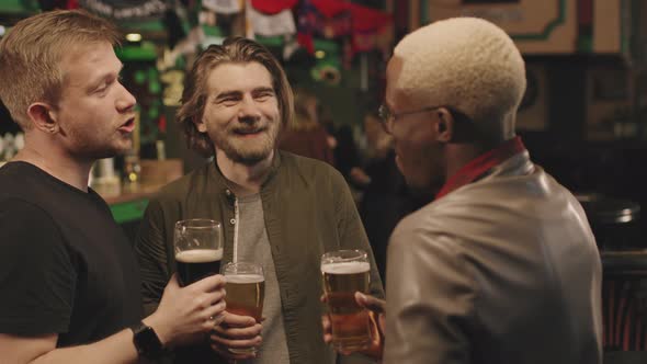 Men With Beers Talking At Pub