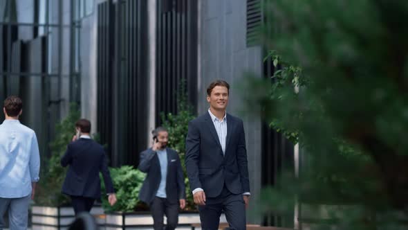Satisfied Businessman Walking Downtown District in Suit Looking in Distance