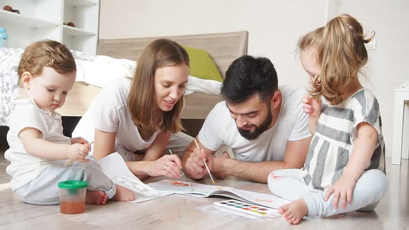 Young Parents Together with Children Draw Watercolor Paints on Paper