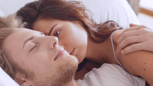 Young Beautiful Caucasian Lovers Lying in Bed in the Morning Embracing