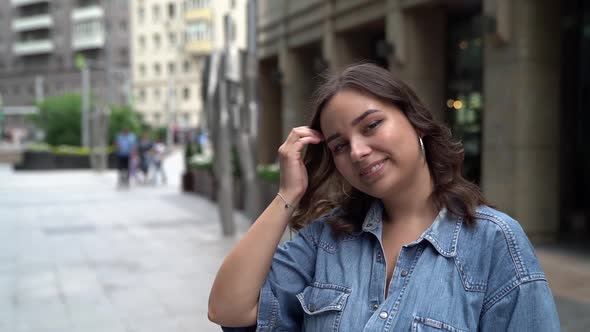 Young Plump Pretty Woman Is Walking in City Street, Looking at Camera, Female Portrait