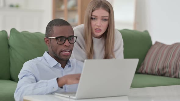 Mixed Race Couple Arguing While Working on Laptop From Home
