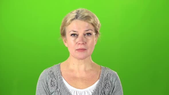 Actress with Glasses Raises Her Head and Starts Smiling . Green Screen