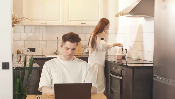 Attractive Woman Talk on Phone While Her Husband Work on Laptop