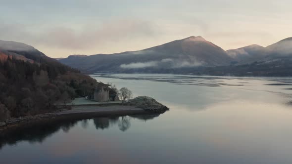 The Historical Castle On The Shores Of Loch Fyne Overlooking The Mountains Under The White Cloudy Sk
