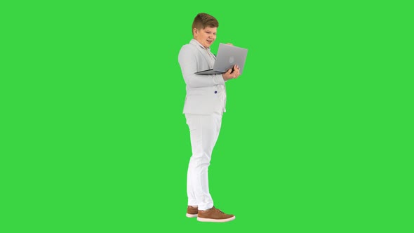 Happy Boy with a Laptop Making Victory Gesture on a Green Screen Chroma Key