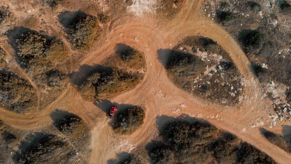 Wide aerial shot looking down on two ATV dune buggies as they enter frame and race around the tracks