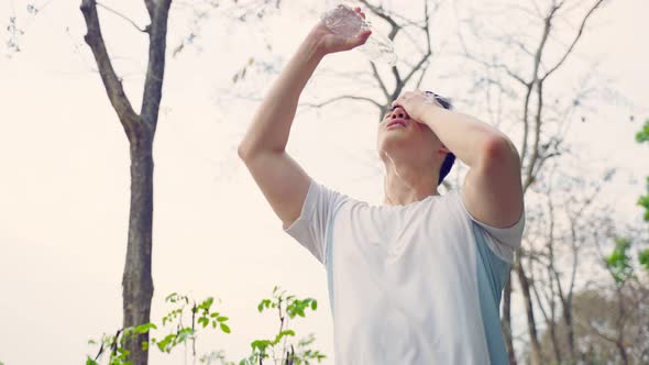 Asian sport male pour water to rinse his face from sweat after workout.