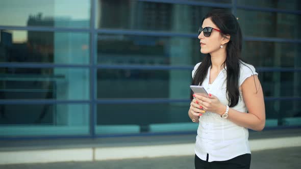 Successful Businesswoman or Entrepreneur with Smartphone Walking Outdoor