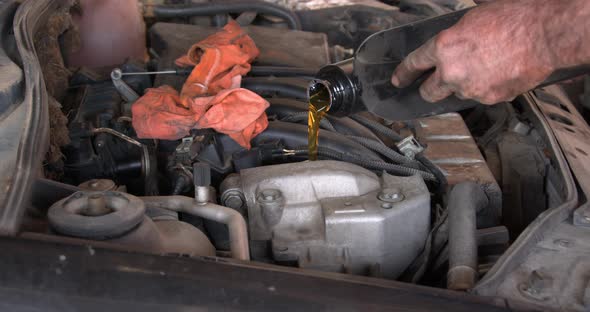 Mechanic Pours Oil Into Car Engine